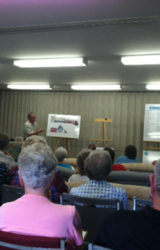 ERMUC-Focus-Group-Presenter,-Gordon-Bell,-describes-elevation-drawings-of-proposed-construction-project-to-full-house