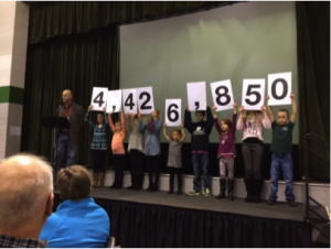 Students help announce the pledge total.