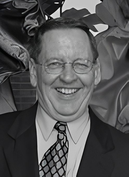 Smiling man with glasses in suit and tie