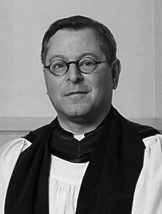 Man in clerical attire and glasses