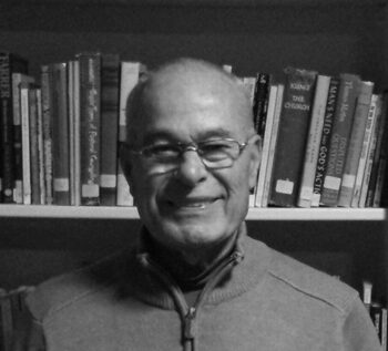 Man smiling in front of bookshelf