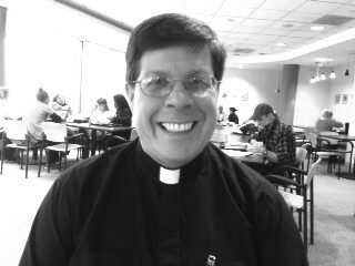 Priest smiling in a cafe