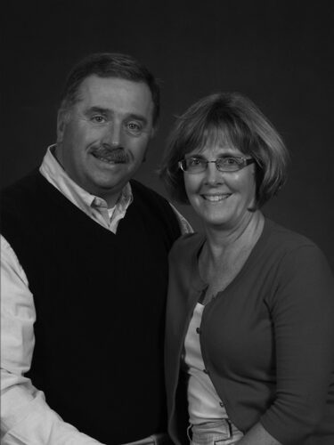 Smiling couple in black and white portrait.