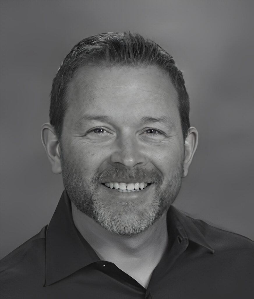 Smiling bearded man headshot on gray background