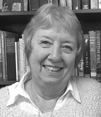 Smiling woman in front of bookshelf