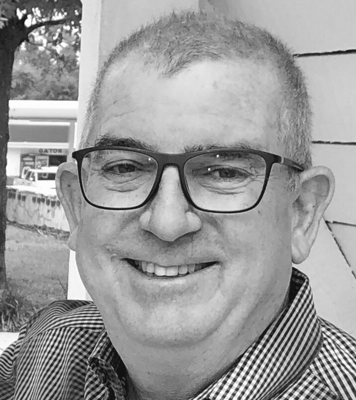 Smiling man wearing glasses outdoors