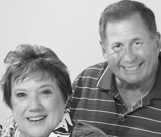 Elderly couple smiling warmly at camera