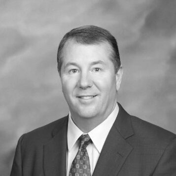 Professional headshot of smiling man in suit