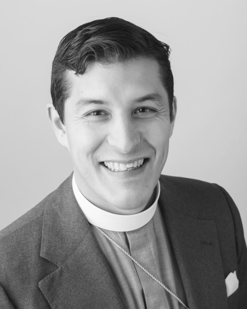 Smiling man in suit and clerical collar