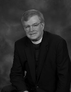 Priest smiling in formal suit
