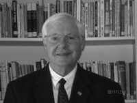 Man in suit with bookshelf background