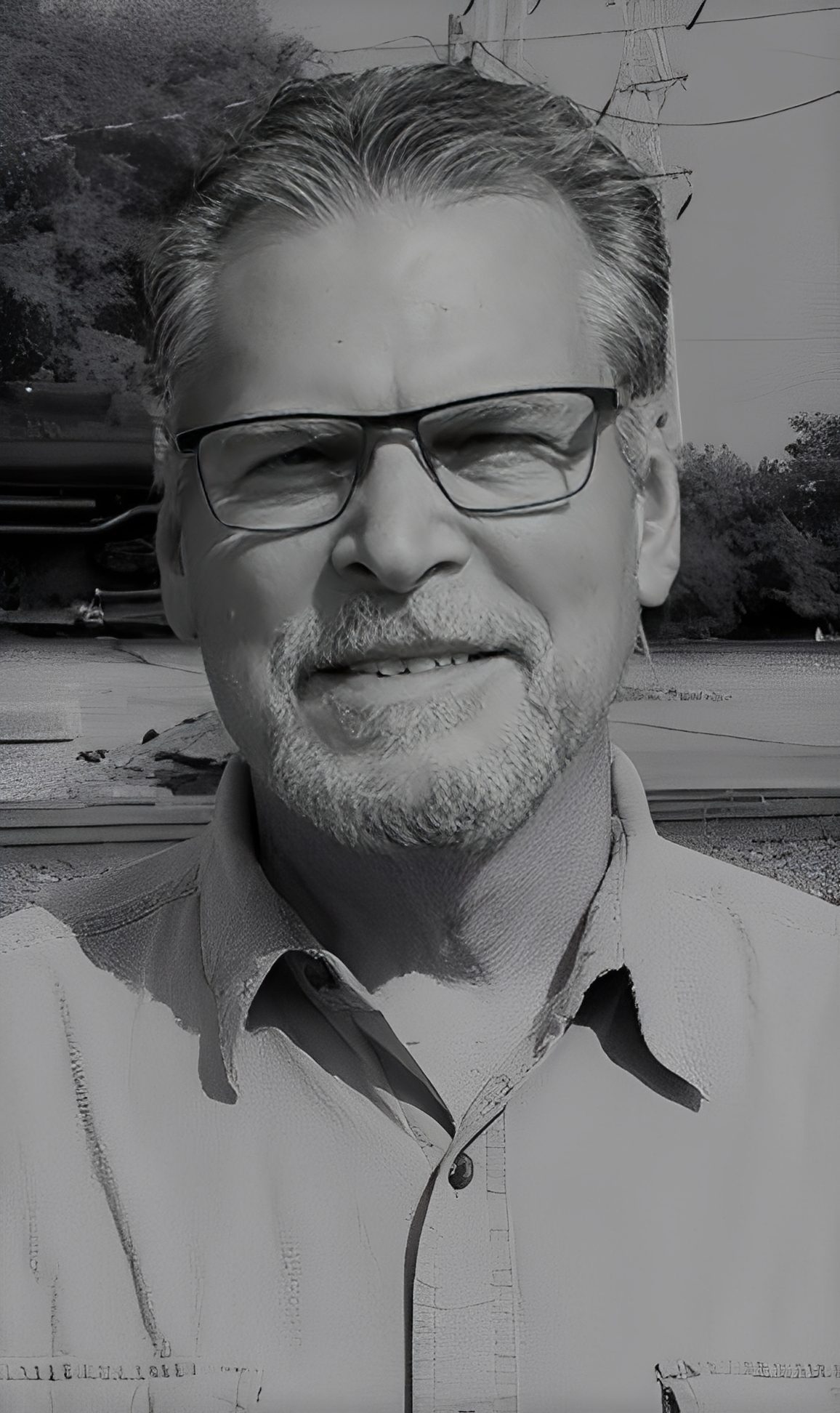 Smiling man with glasses outdoors