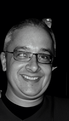 Black-and-white portrait of smiling man with glasses