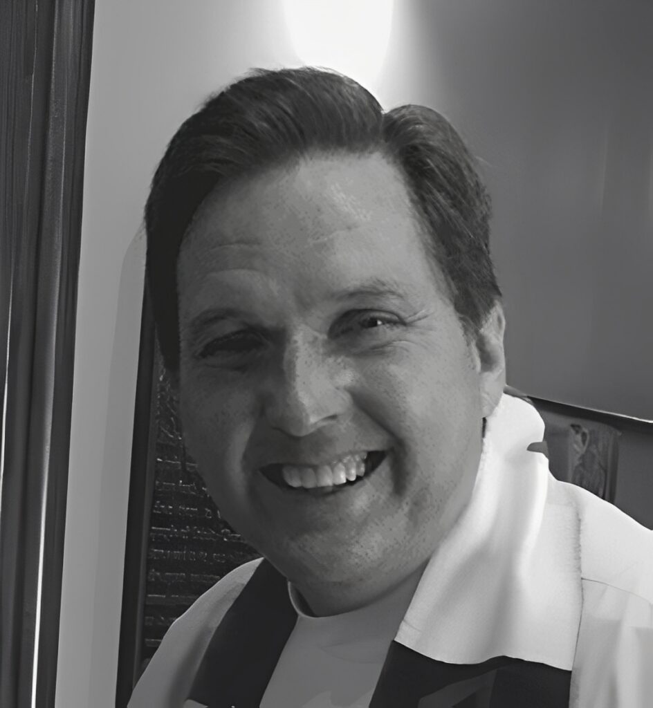 Smiling man in collared shirt, black and white