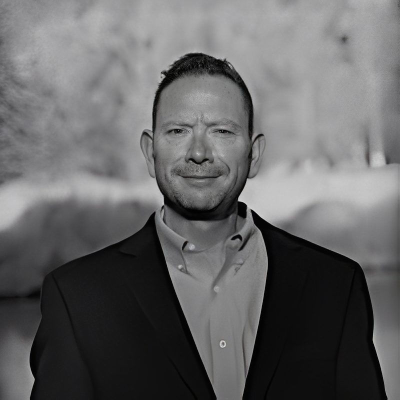 Black-and-white portrait of smiling man wearing suit