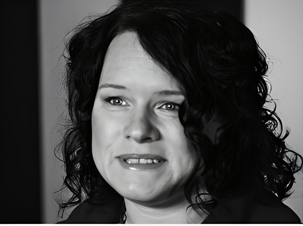 Smiling woman with curly hair in grayscale