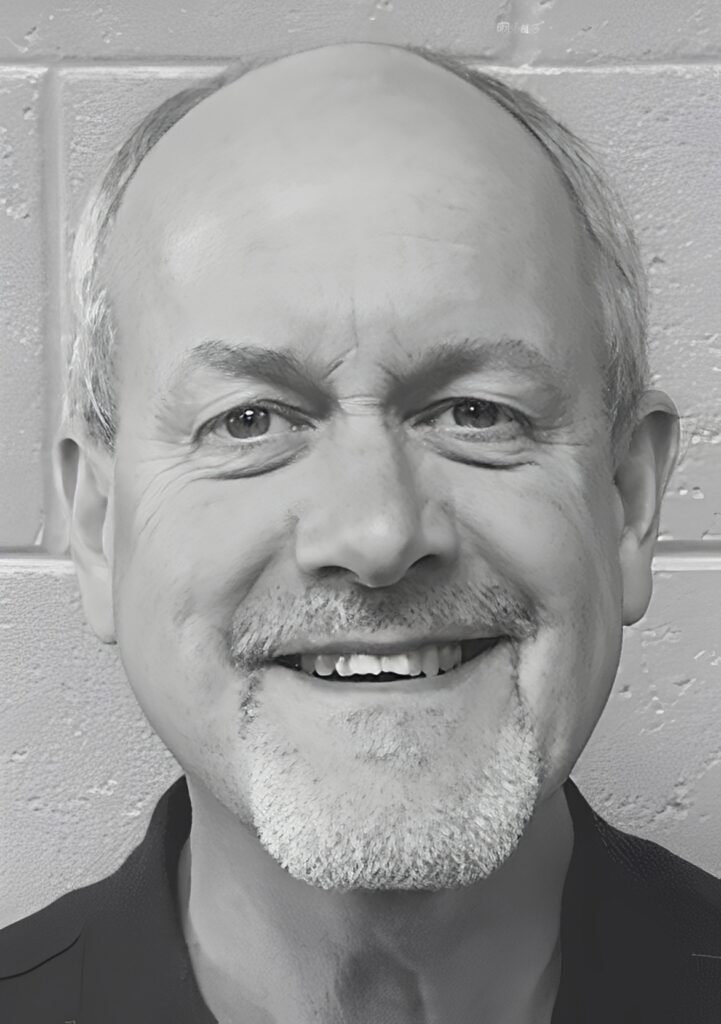 Smiling bald man with gray goatee