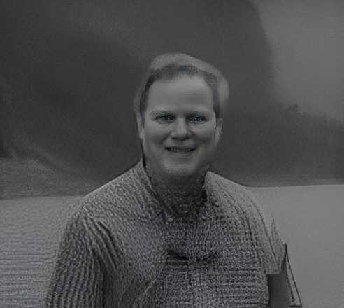 Smiling person wearing textured sweater, grayscale