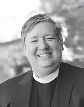 Smiling clergyman wearing clerical collar portrait