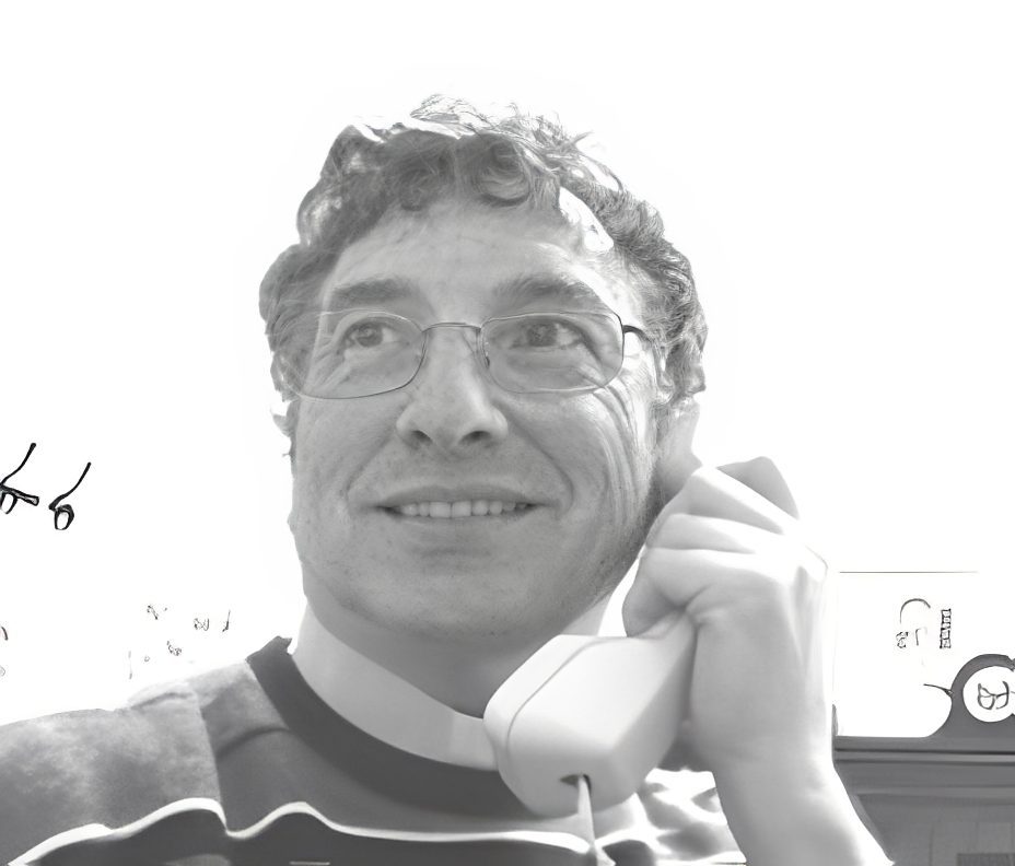 Smiling man with glasses talking on phone