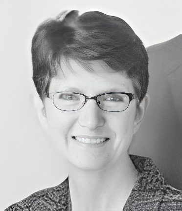 Smiling person with glasses, short hair, professional headshot